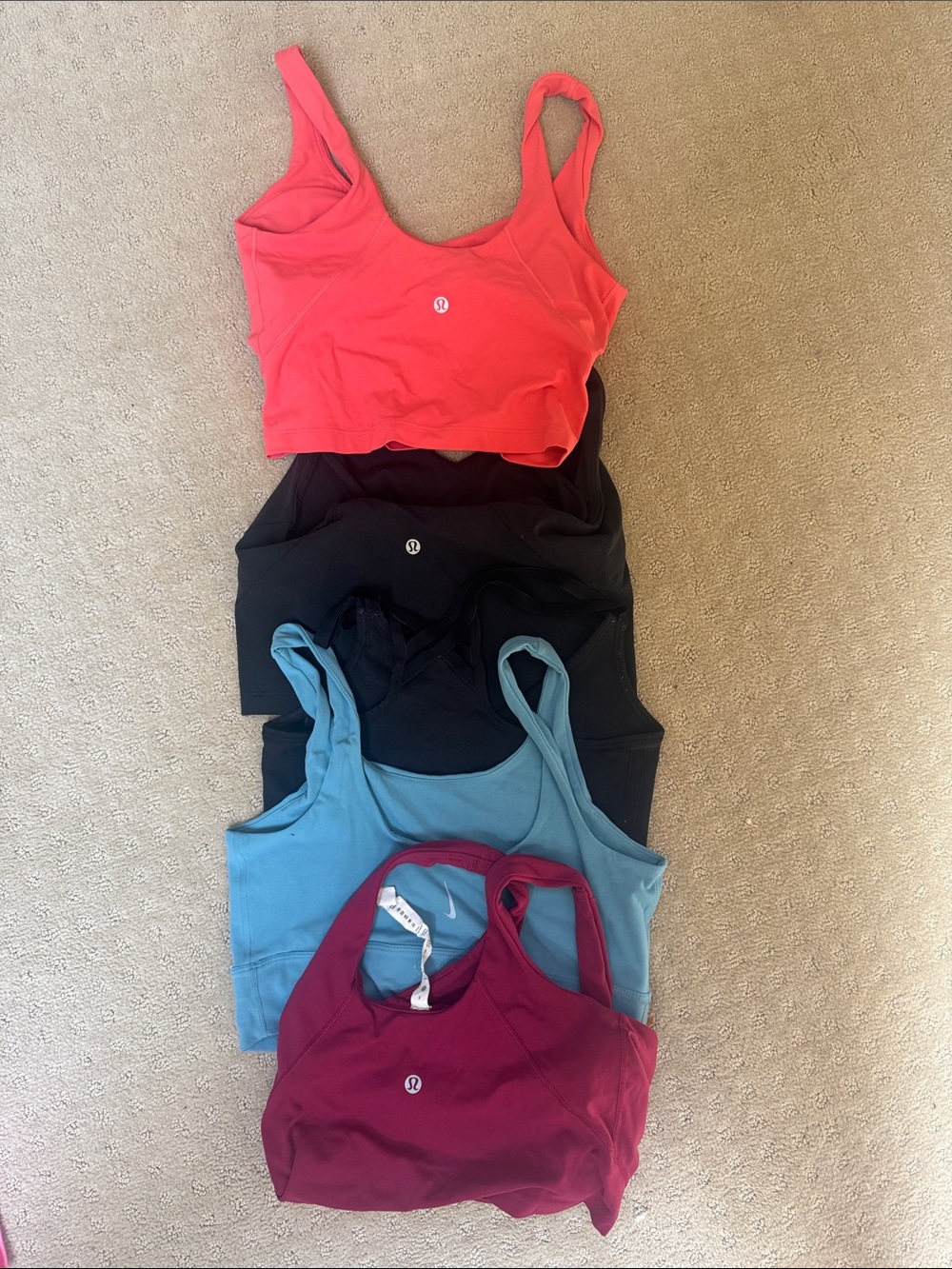 lululemon athletica sports bras in coral, black, teal, and burgundy